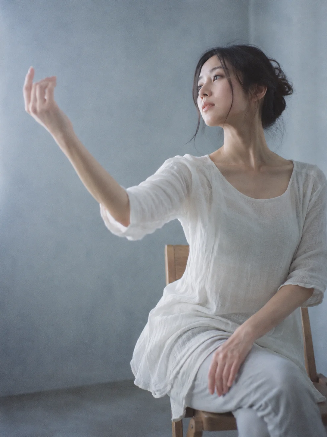 Seated Dancer Raising an Arm by a Window — AI-generated photograph