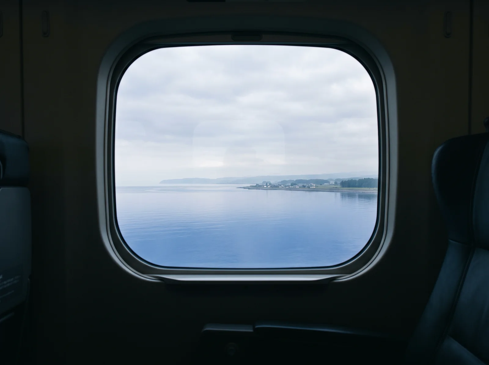 Calm Coast Through a Shinkansen Window — AI-generated photograph
