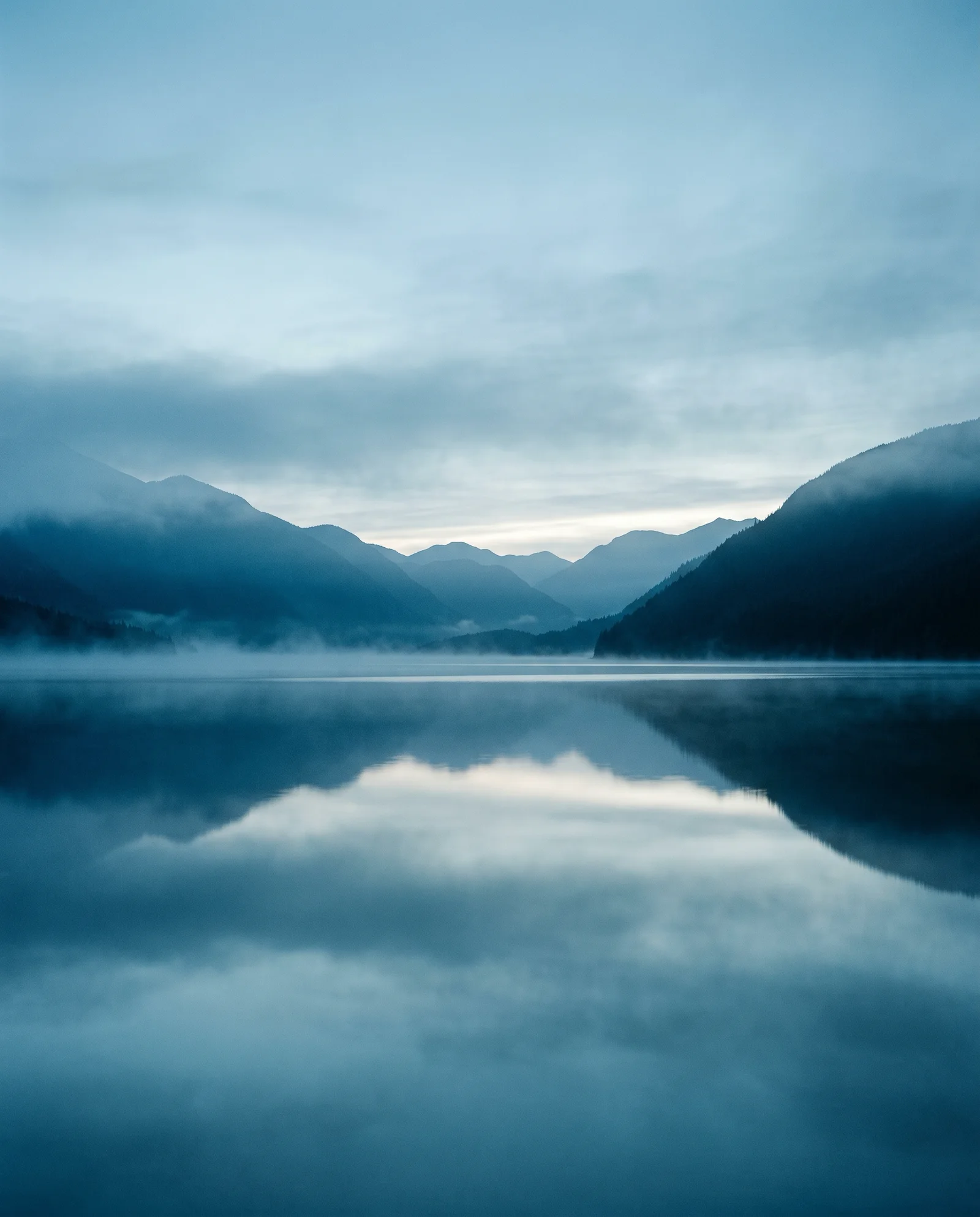 Mist-Layered Lake Ridges in Cool Light — AI-generated photograph