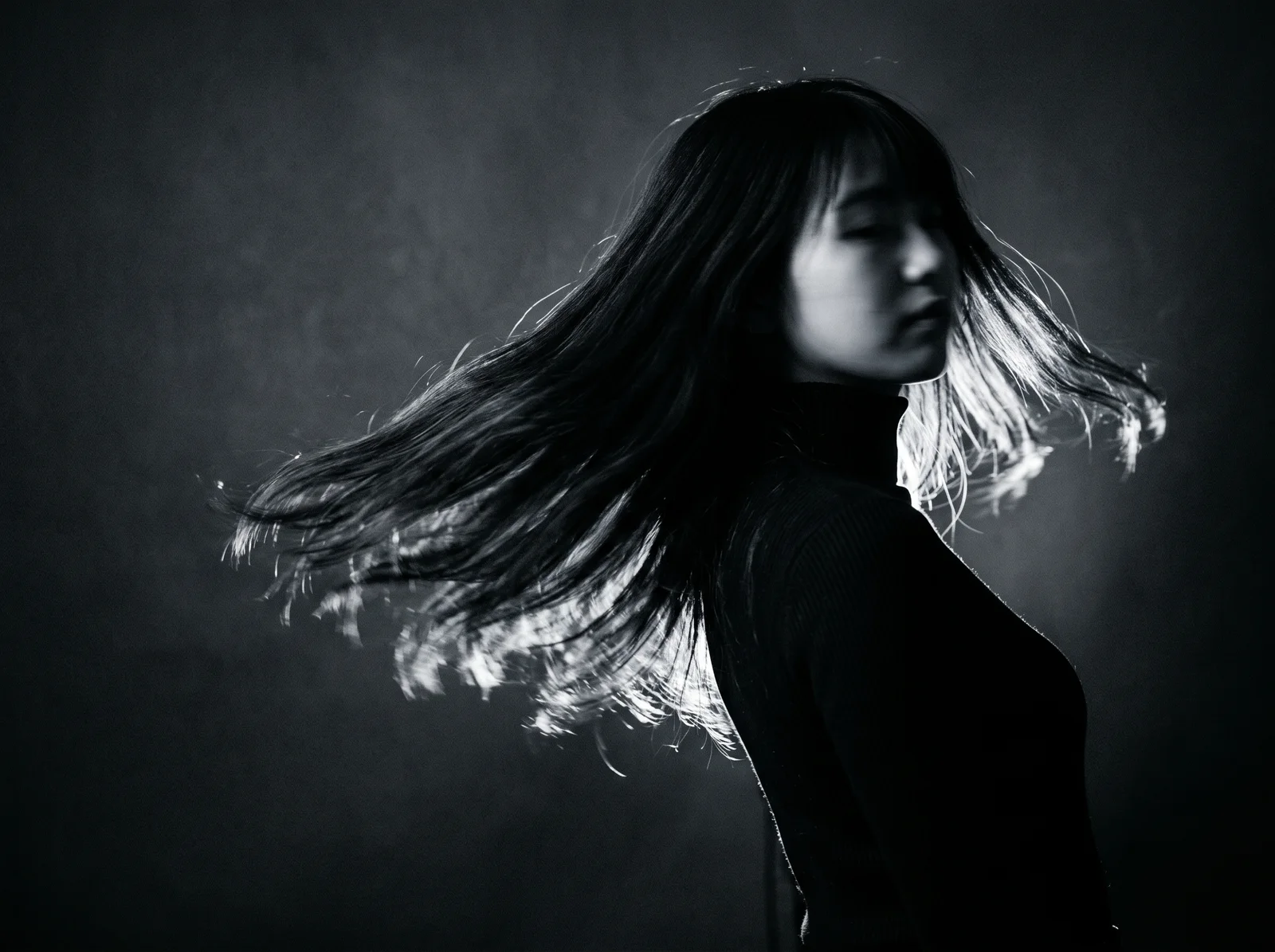 Woman Turning with Hair Sweeping in Monochrome — AI-generated photograph