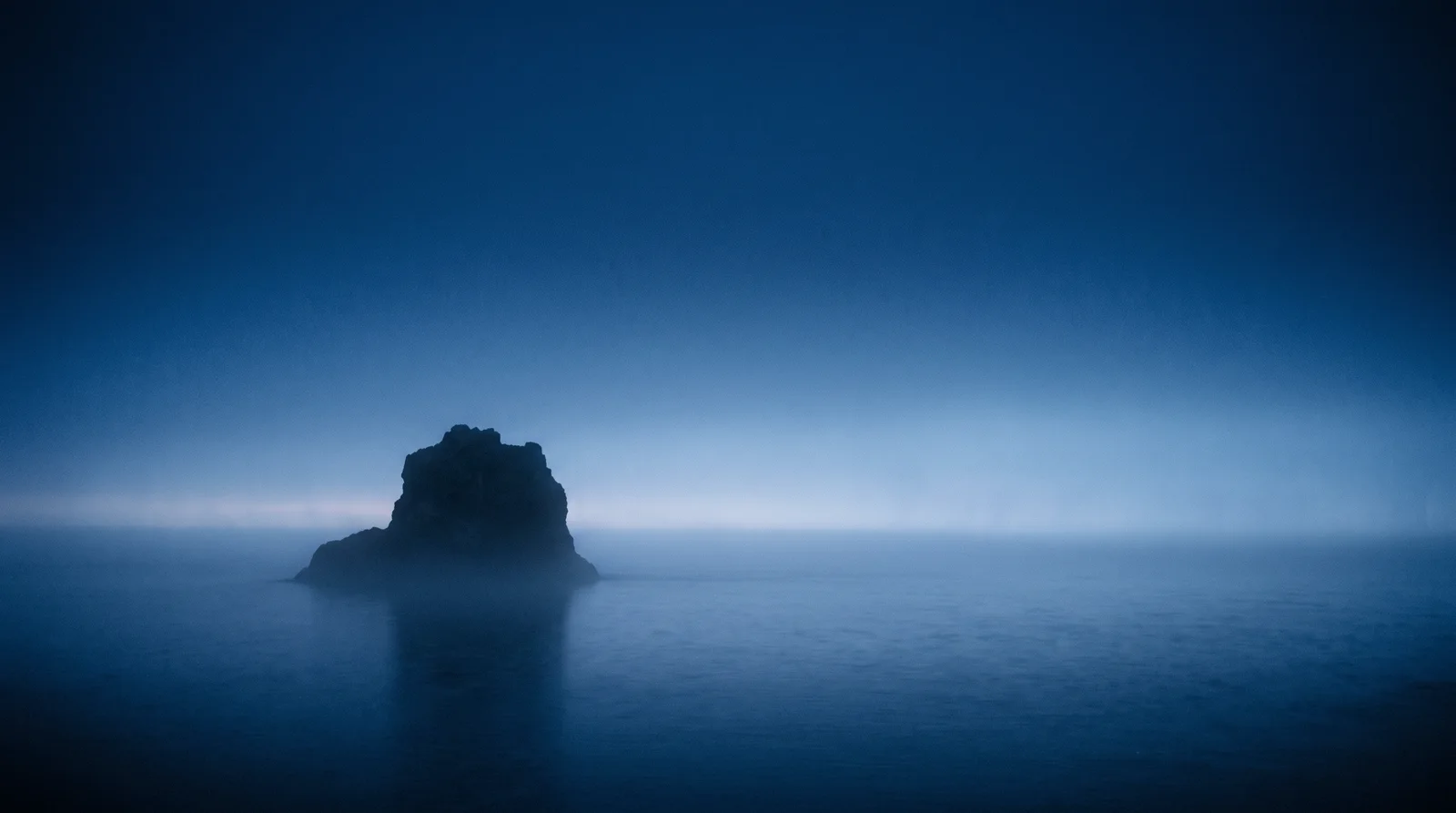 Sea Stack Silhouette in Blue Fog — AI-generated photograph