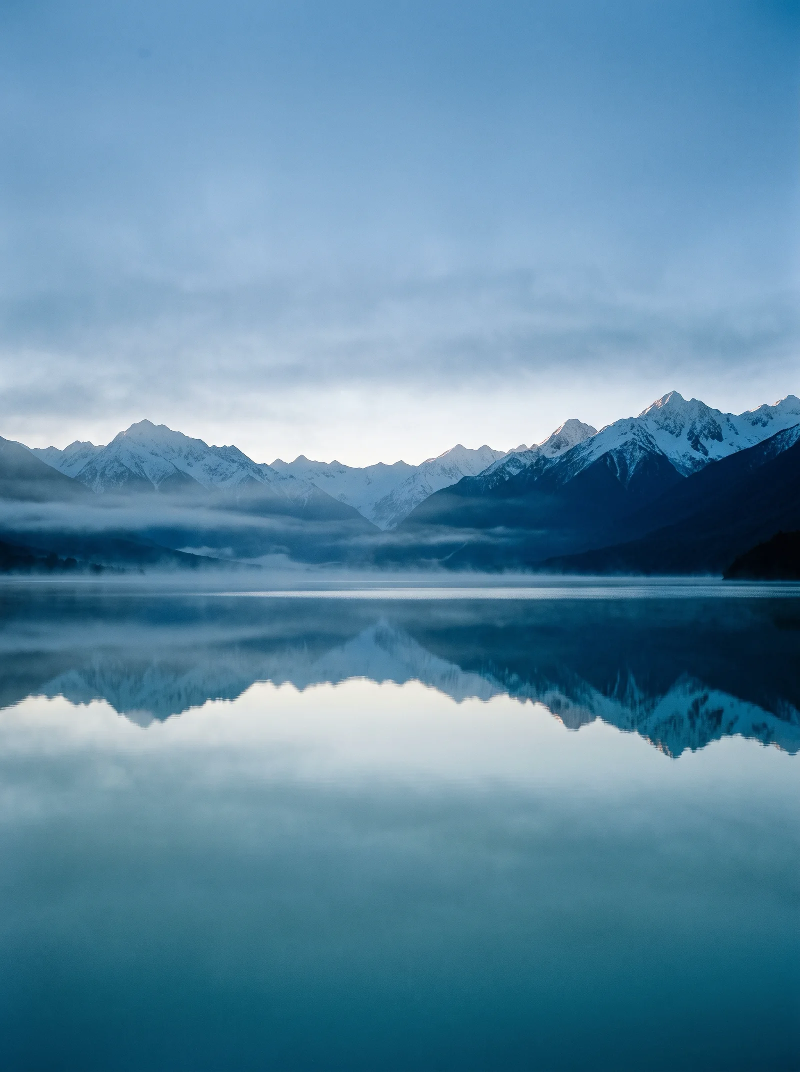 Snowy Ridges Mirrored in a Misty Lake — AI-generated photograph