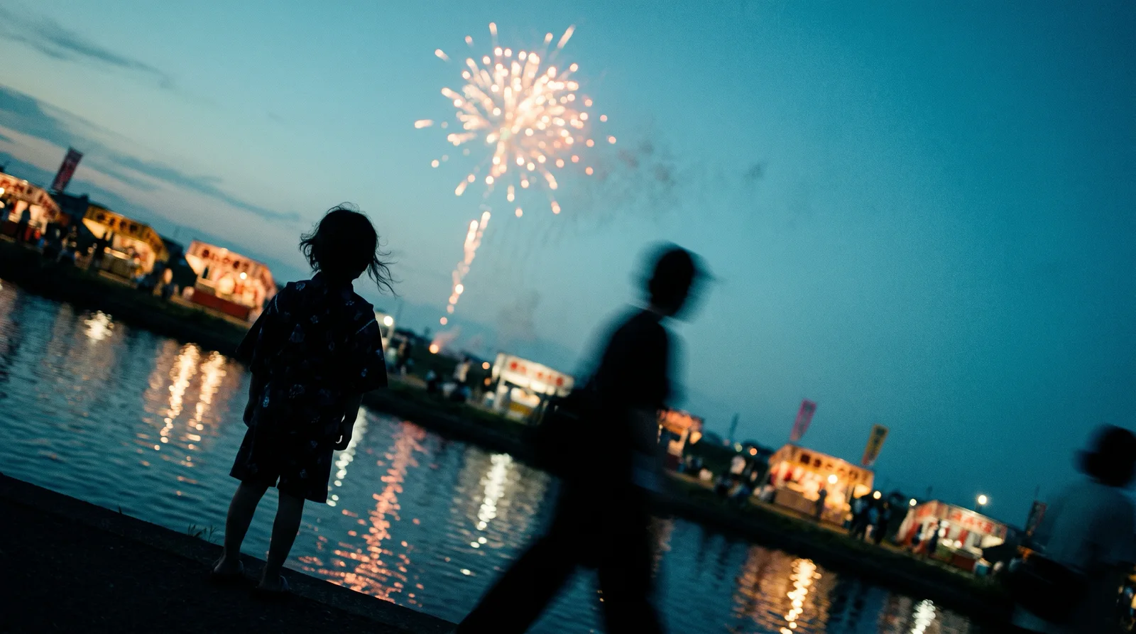 Lone Child Silhouette Before Fireworks Over a River — AI-generated photograph