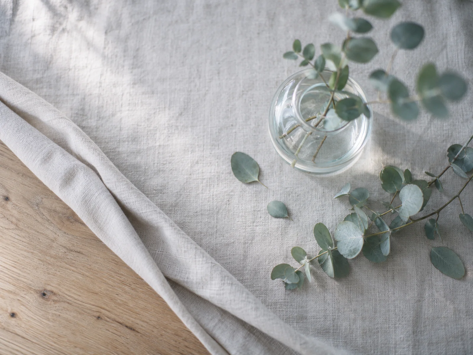 Upright Eucalyptus Above Folded Linen — AI-generated photograph