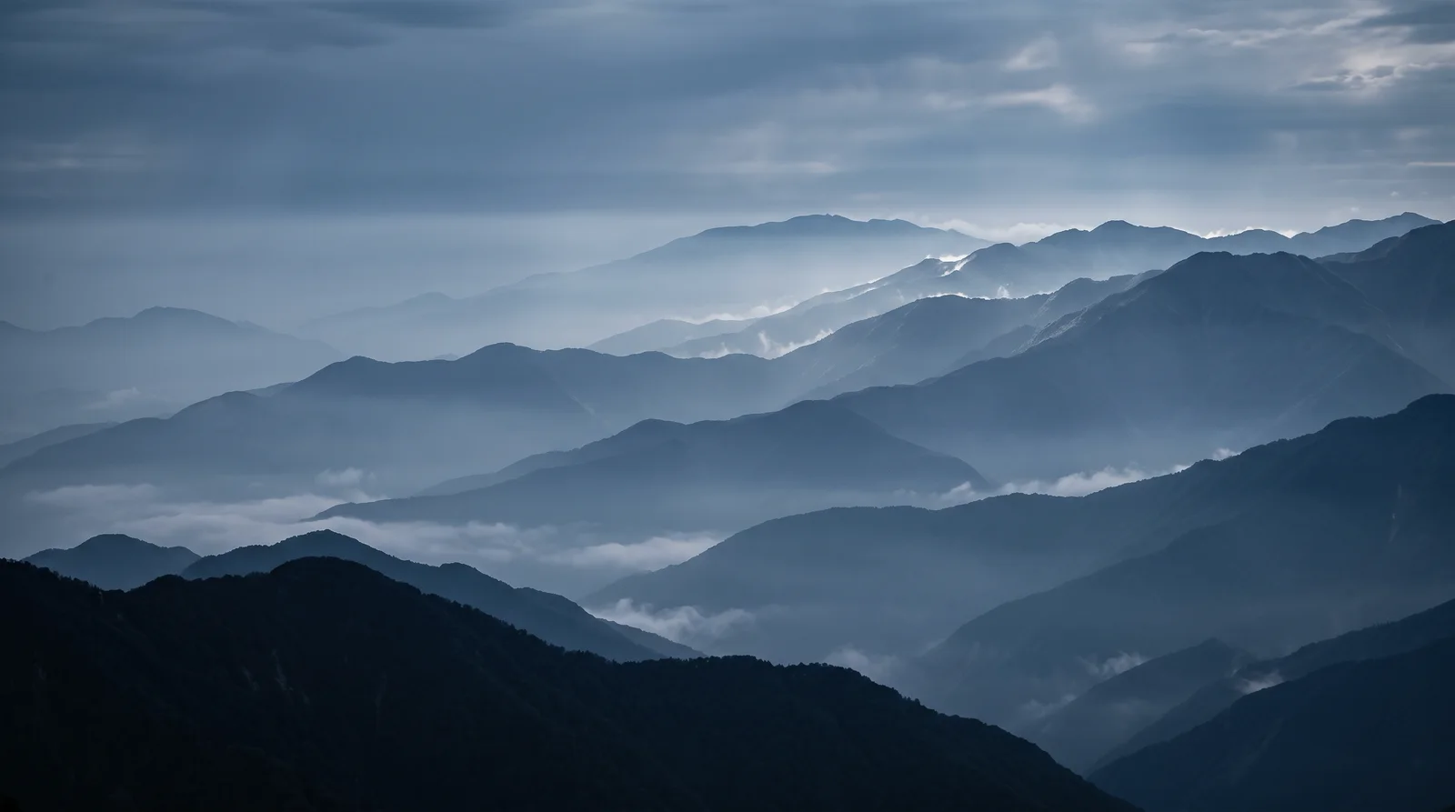 Layered Mountain Ridges in Blue Haze — AI-generated photograph
