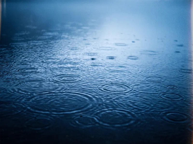 Rain Dimpling a Blue Misty Water Surface — AI-generated photograph
