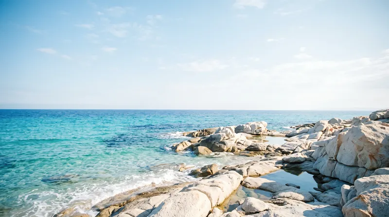 Turquoise Sea Washing Pale Granite Rocks — AI-generated photograph