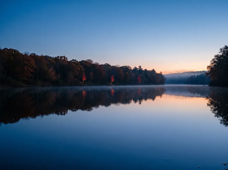 Autumn Bank Mirrored in a Still Ravine Pool at Dusk — AI-generated photograph