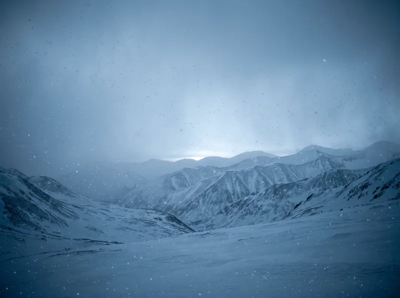 Snow Falling Over Misty Layered Ridges — AI-generated photograph