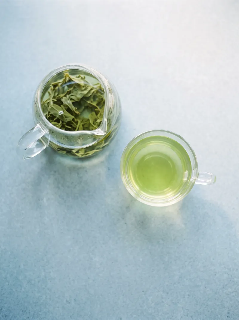 Overhead View of a Glass Teapot and Green Tea — AI-generated photograph