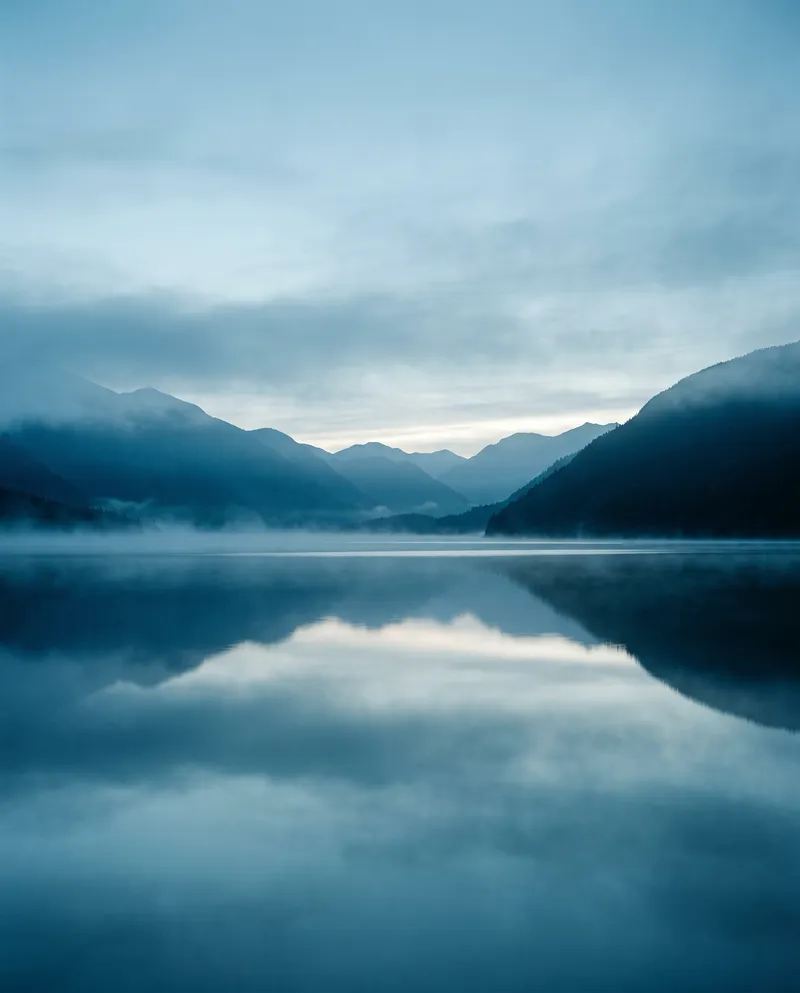 Mist-Layered Lake Ridges in Cool Light — AI-generated photograph