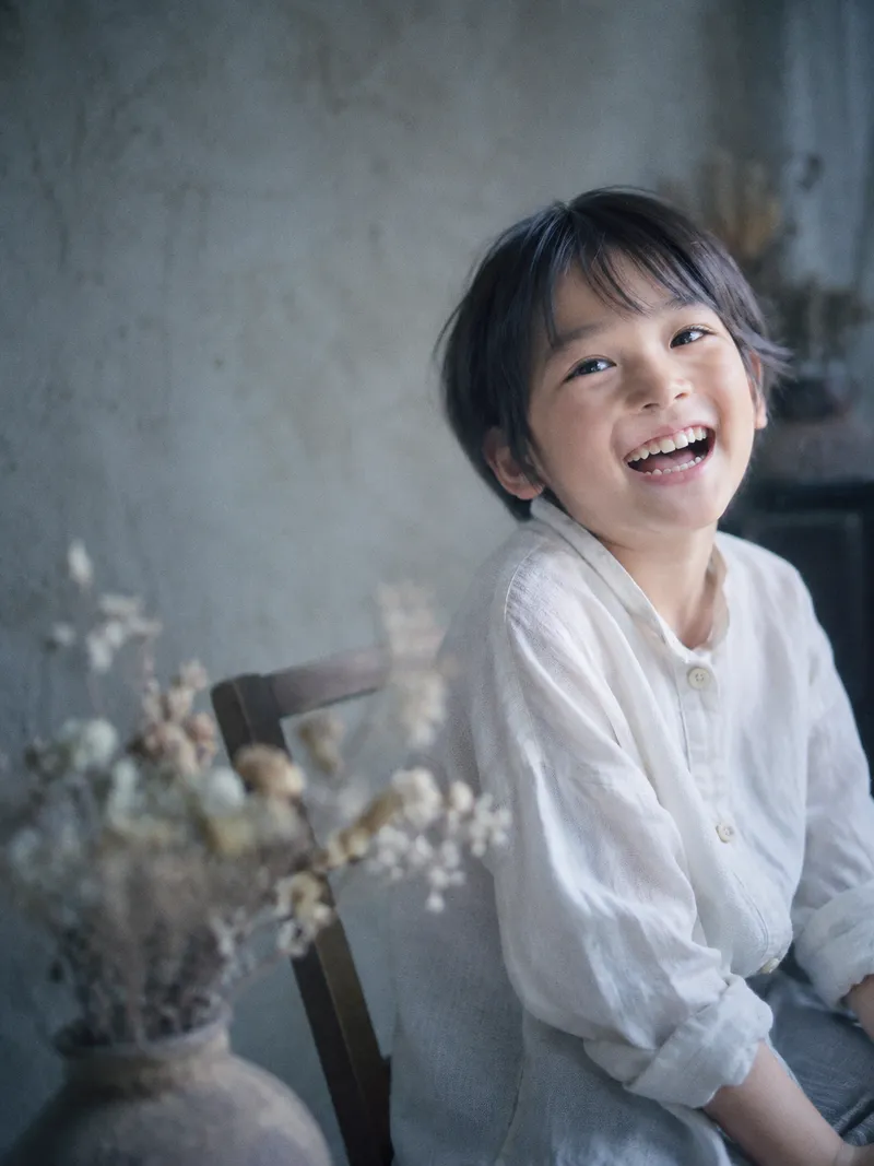 Smiling Child Seated in a Bright Room — AI-generated photograph